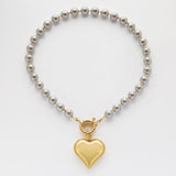 Велике золоте серце на сірих перлах