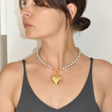 Велике золоте серце на сірих перлах